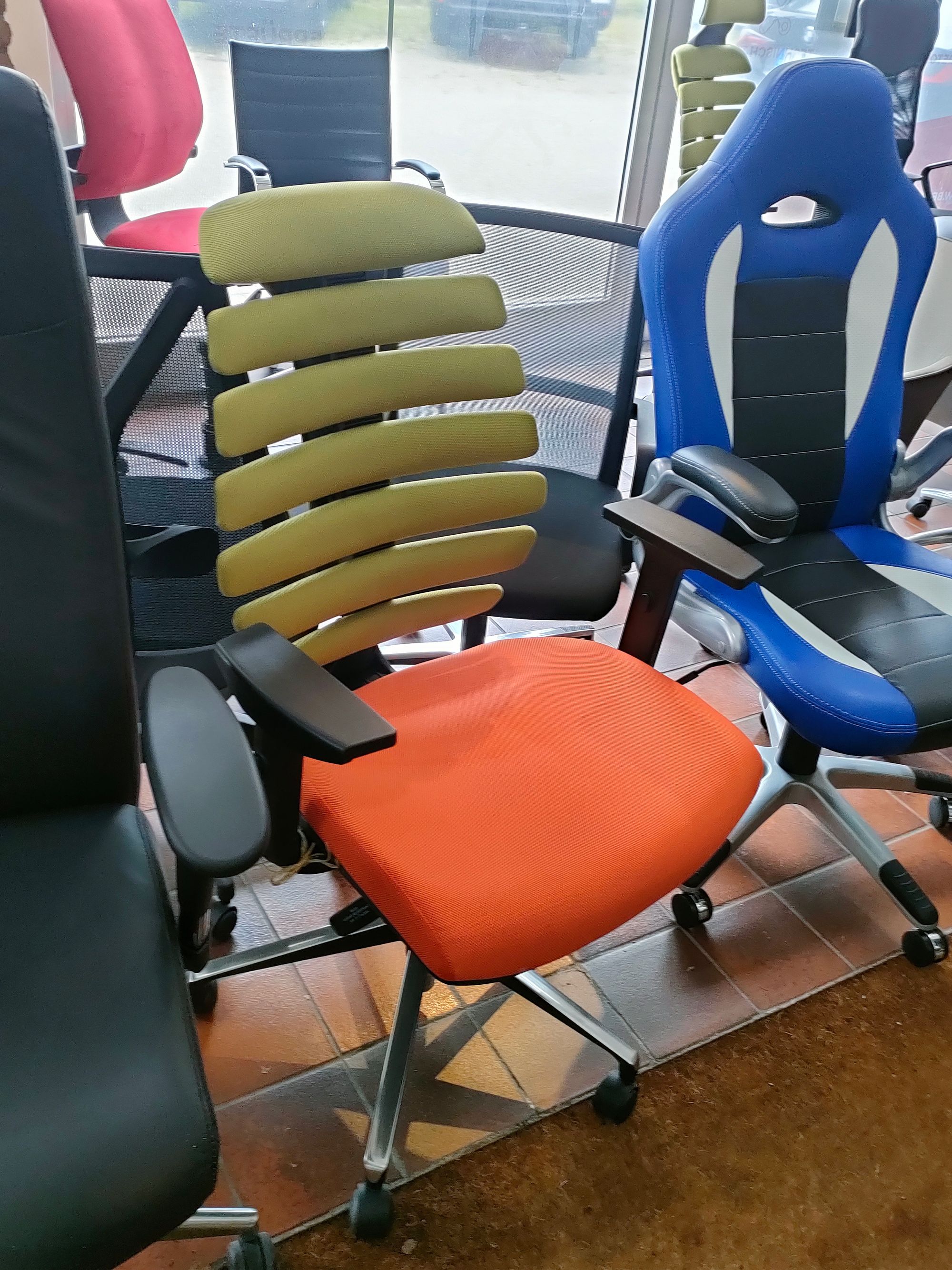 Ein Bürostuhl mit oranger Sitzfläche und grüner Rückenlehne