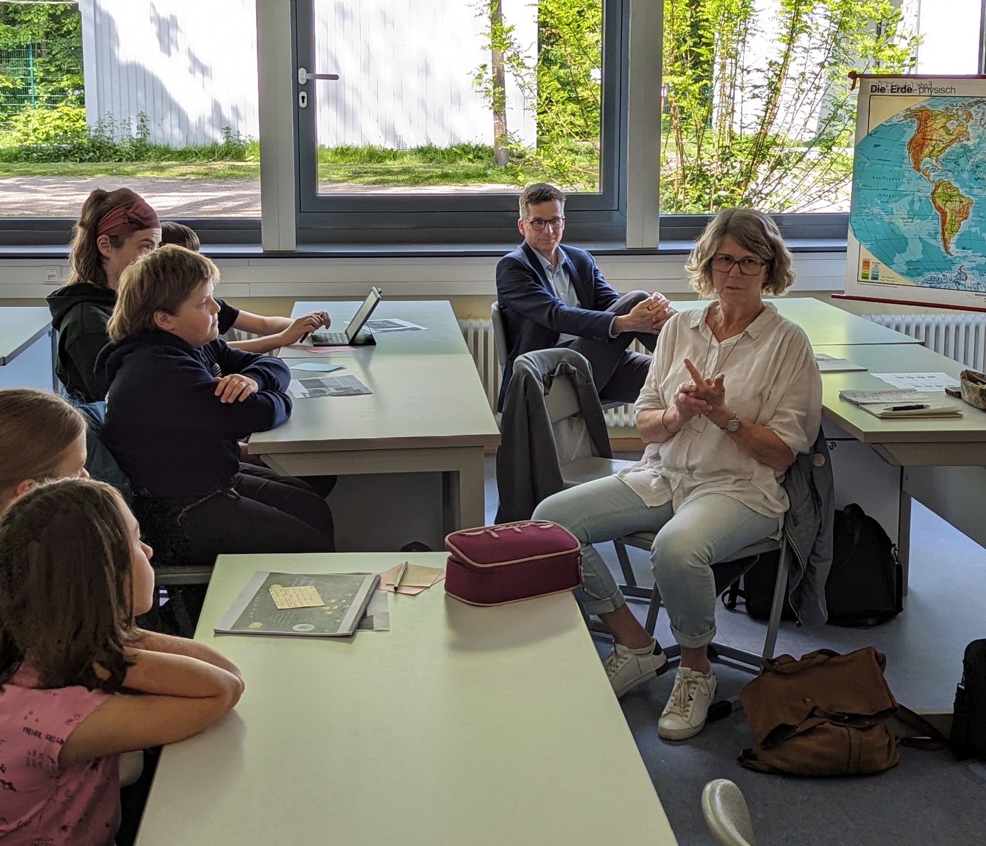 Susanne Menge diskutiert mit Schüler:innen in einem Physikraum