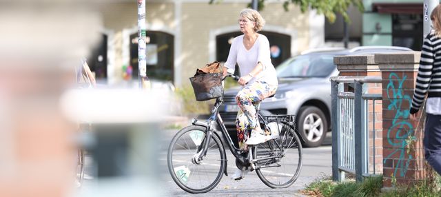 Susanne Menge auf einem Fahrrad in der Oldenburger Innenstadt. Ihr Gesichtsausdruck ist ernst.